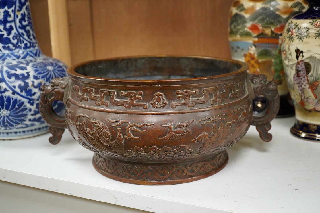 A large Chinese archaistic bronze censer, decorated in relief, with twin handles, 38cm in diameter